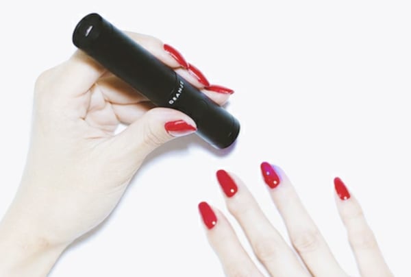 コードレスのハンディネイルライトで照射する様子