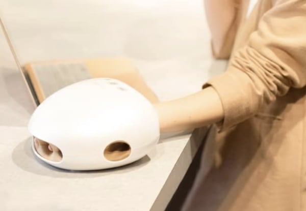 ハンドマッサージャーに手を入れる女性