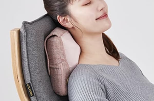 ネックマッサージャーを使う女性