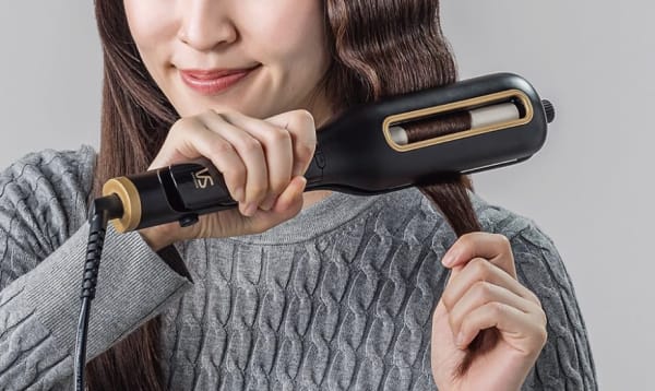 ウェーブアイロンで髪を巻く様子