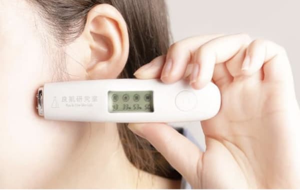 スキンチェッカーを肌に当てる女性