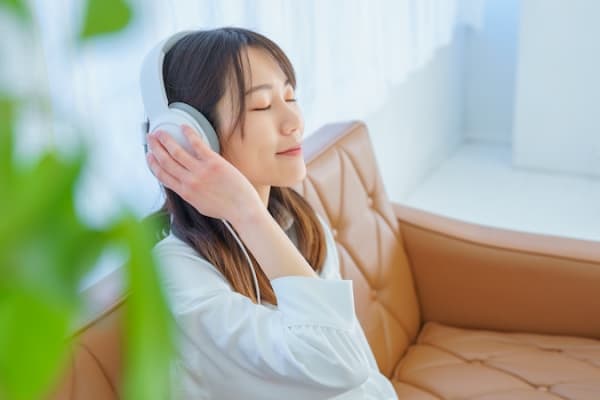 ヘッドホンで音楽を聞く女性