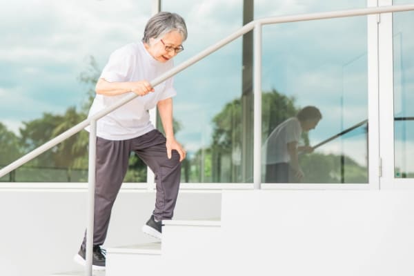 階段を登る老人女性