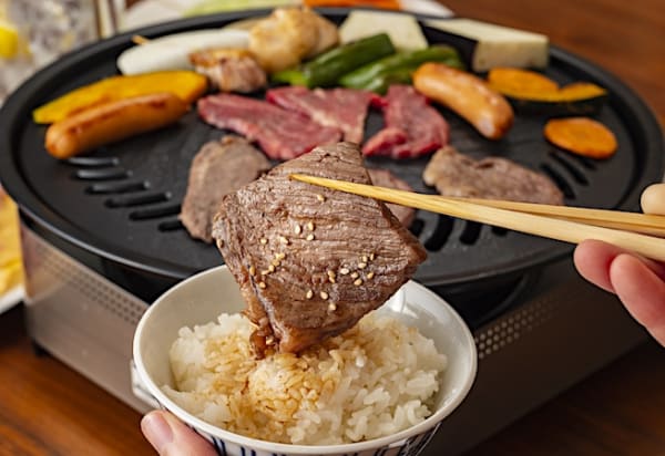 焼き肉をライスの上に乗せる様子