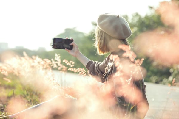 スマホで自撮り撮影する女性