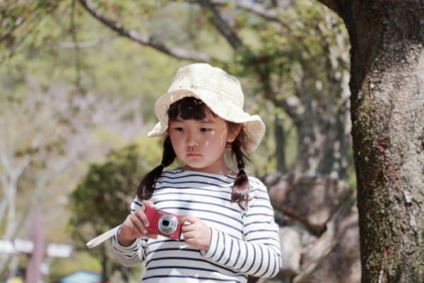 カメラを持ち歩いて散歩する子ども