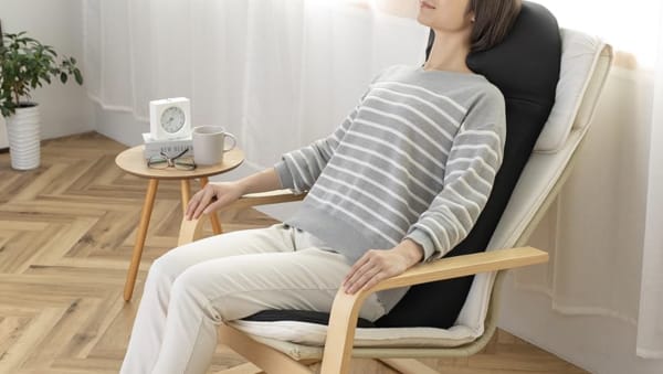 椅子に座ってマッサージシートを使う女性