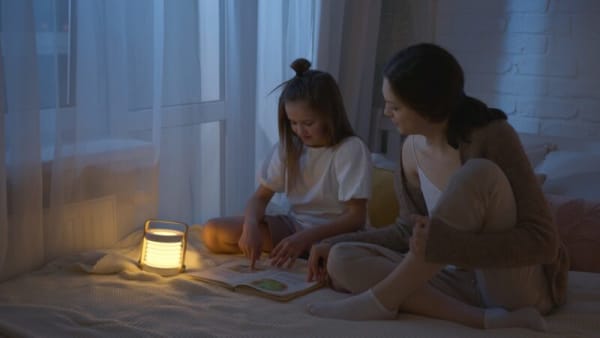 ランタン型の懐中電灯を使用してくつろぐ親子